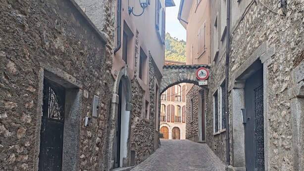 A narrow cobblestone street flanked by historic stone buildings with arched doorways and a no parking sign. - Holiday Home 'Casa Storica Gardola' with Lake View, Wi-Fi and Air Conditioning (Tignale)