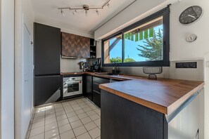 Eine moderne Küche mit Holzarbeitsplatte, eingebauten Geräten und einem Fenster mit Blick.