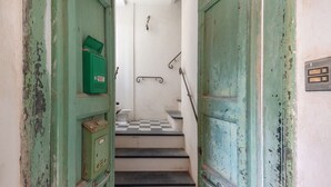 A staircase with a checkered floor leading to a room with a green door and a green electrical box on the wall. - Apartment 'Piter' with Private Terrace (Bonassola)