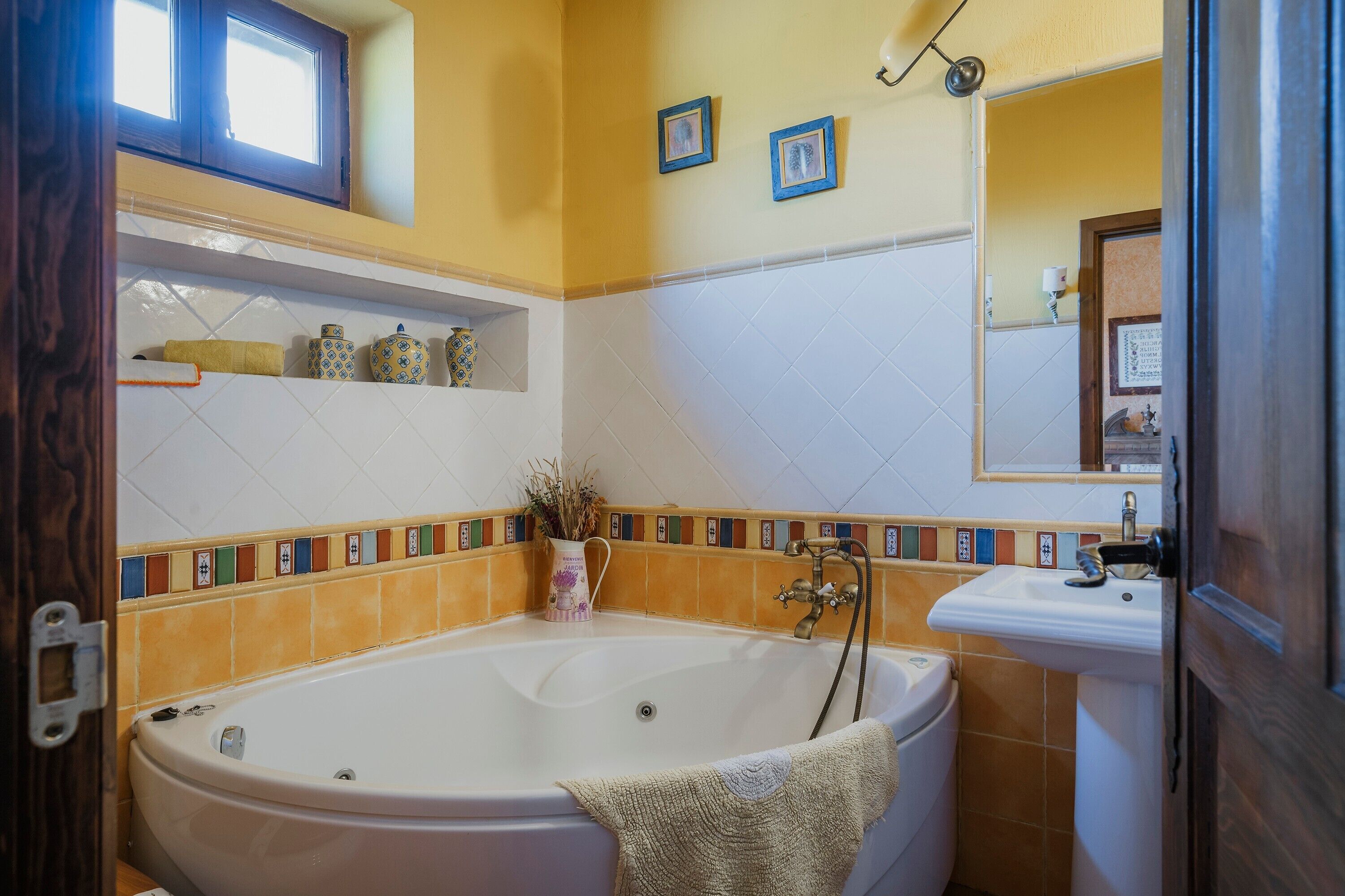 Un baño con una bañera, un lavamanos y un espejo.