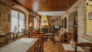 Una sala de estar acogedora con chimenea, muebles de madera y un televisor.