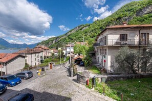 A residential area with stone buildings, a cobblestone street, and a mountain backdrop. - Holiday Apartment "House Of Sport" with Lake View, 2 Shared Terraces & Wi-Fi (Mandello del Lario)