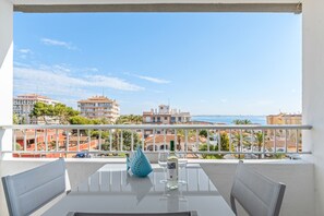 A balcony with a table, chairs, and a decorative blue vase. - Apartment 'Beach Front Sea View Punta Prima' with Sea View, Wi-Fi and Air Conditioning (Torrevieja)