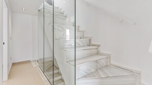 Een trap met glazen balustrades en marmeren treden.