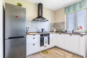 Eine Küche mit einem Edelstahl-Kühlschrank, einem Herd und einem Fenster mit Blick.