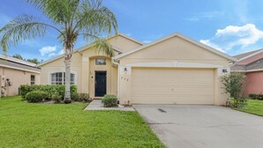 A single-story house with a beige exterior, a black front door, and a garage. - Stunning Newly Renovated Pool Home close to Disney (Davenport)