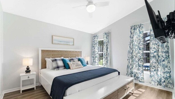 A bedroom with a bed, nightstand, and a ceiling fan. - Stunning Newly Renovated Pool Home close to Disney (Davenport)