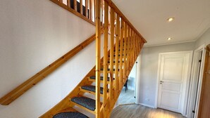A wooden staircase with carpeted steps leading to a landing. - ETW Hausberg 45 - Fr. Schwenn - Großzügiges Ferienappartement in Ruhiger Wohnsiedlung (Sassnitz)