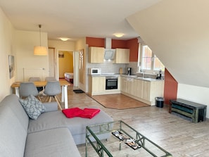A modern apartment with a living room, kitchen, and dining area.