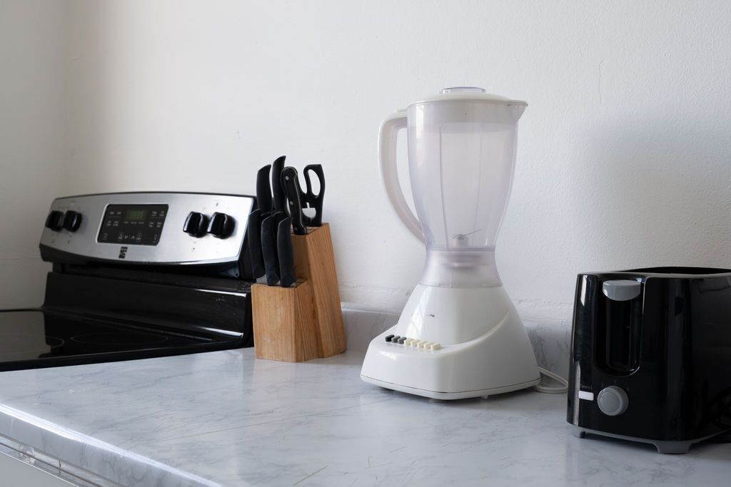 Eine Küche mit Herd, Mixer, Toaster und einem Messerblock.