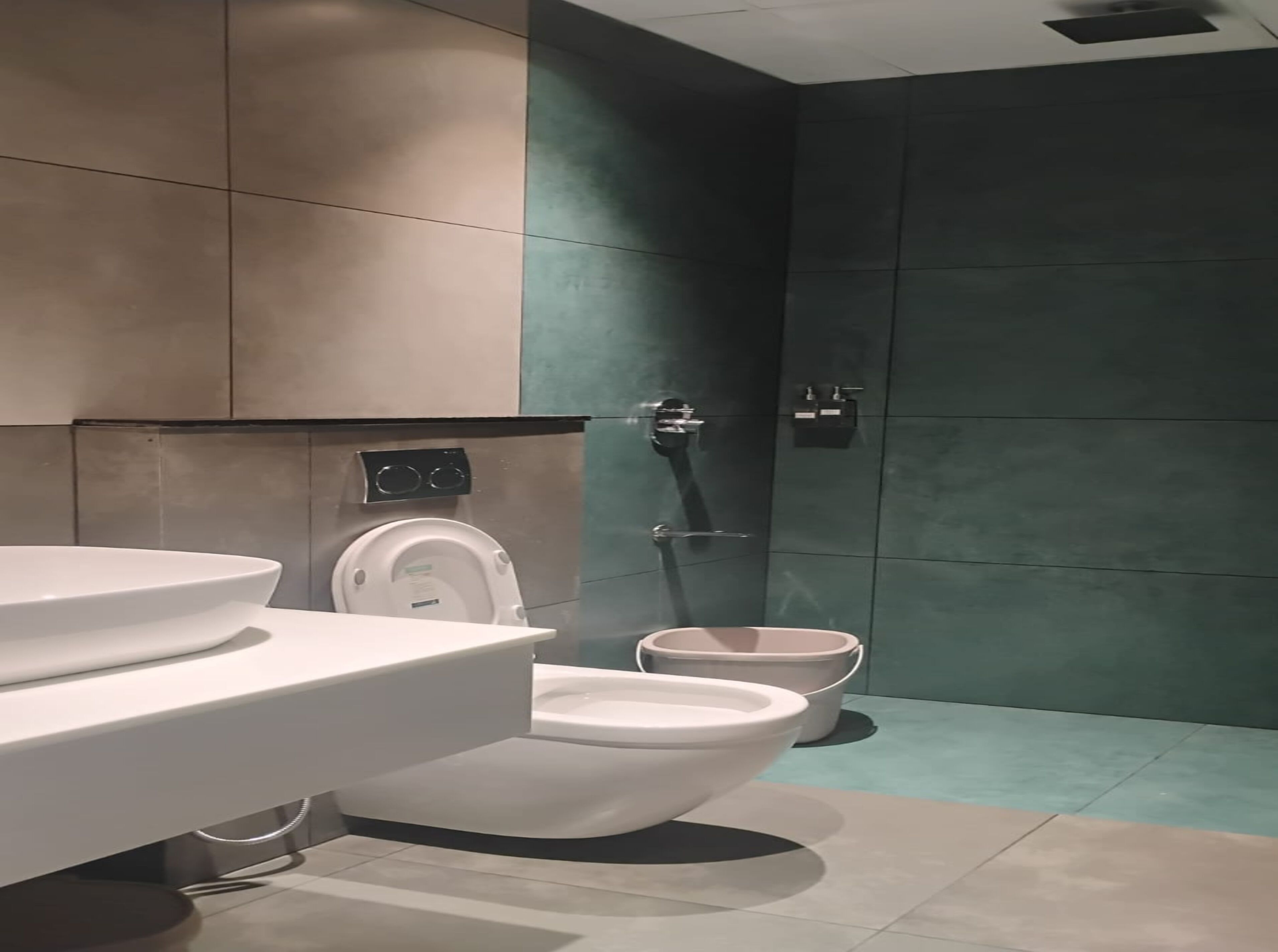 A modern bathroom with a toilet, bidet, and sink.