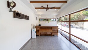 A reception area with a wooden bench, a clock, and a sign that reads "UNTEL WILD".