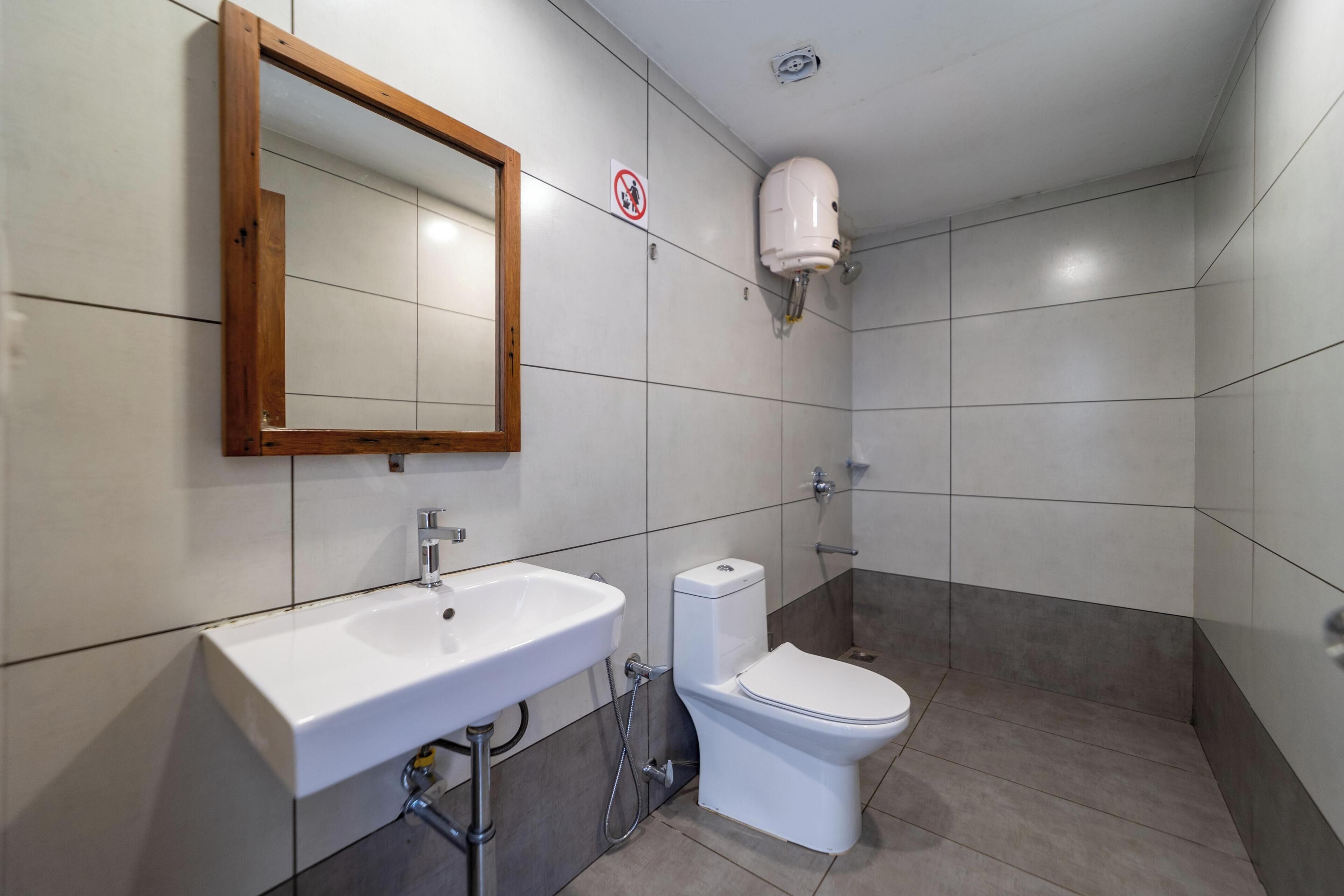 A bathroom with a white sink, a toilet, and a mirror.