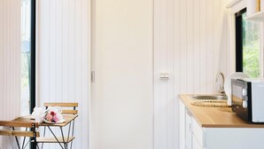 Eine kleine Küche mit einer Holzausziehtafel, einem Spülbecken und einem Fenster.