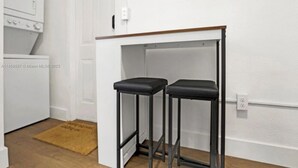A kitchen with a white refrigerator, a microwave, and a wooden countertop. - HOT TUB + WASHER AND DRYER in Unit / MIAMI (Miami)