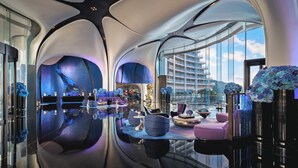 A modern interior with a reflective floor, contemporary furniture, and large windows offering a view of a high-rise building. - MGM Shenzhen (Shenzhen)
