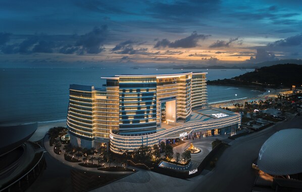 A multi-story hotel with a curved facade, located near a body of water. - MGM Shenzhen (Shenzhen)