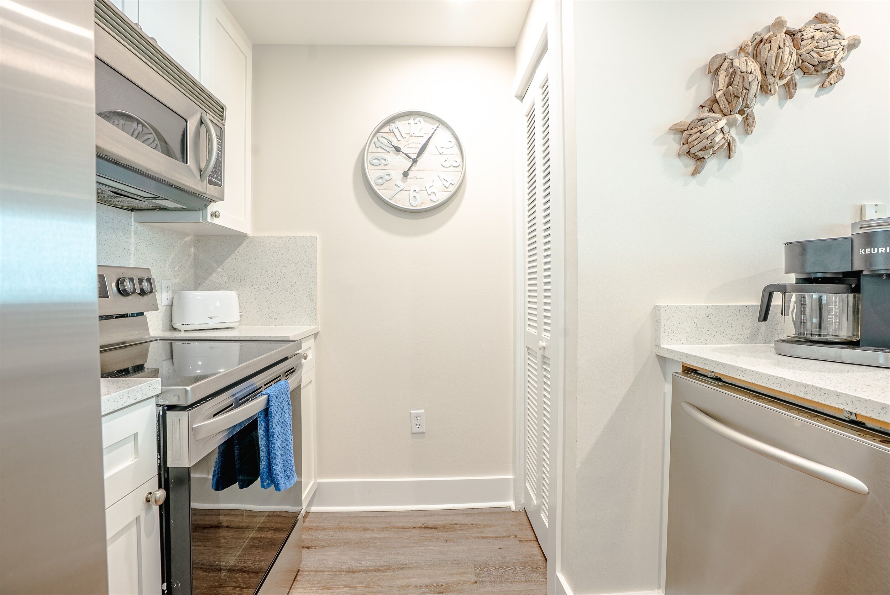 A modern kitchen with a built-in oven, microwave, and coffee maker.