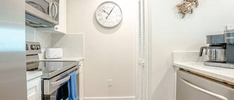 A modern kitchen with a built-in oven, microwave, and coffee maker.