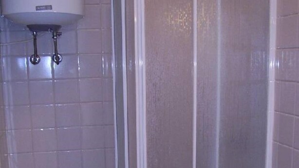 Une salle de bain comprenant des toilettes, un espace douche et un lavabo.