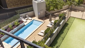 A rooftop swimming pool with lounge chairs, a small building, and a tennis court. - Mounts Bay Stay Two Bedroom Apt.   Near Kings Park - Free Parking - Wi-Fi (Perth)