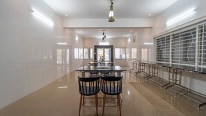 A spacious, modern kitchen with a central island, ample natural light from large windows, and a sleek, minimalist design. - Treebo The Regalia Rooms With Mountain View (Kodaikanal)