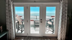 Ein Zimmer mit Blick auf den Ozean durch eine Schiebetür.
