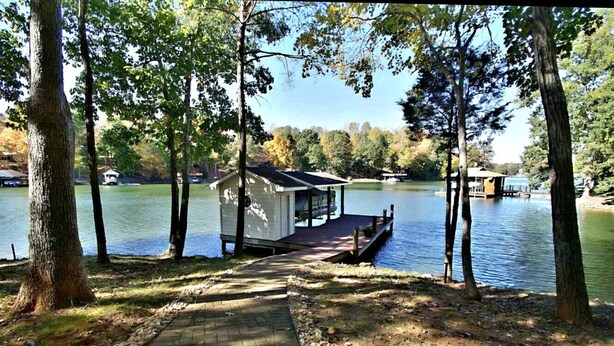 A dock extending into a lake with a small cabin-like structure at the end. - Something Special - Firepit / Game/Movie Room / Dock (Moneta)