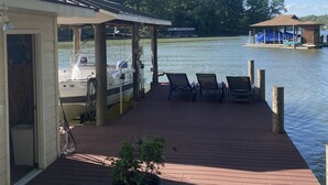A wooden dock with lounge chairs and a covered seating area overlooking a lake. - Something Special - Firepit / Game/Movie Room / Dock (Moneta)