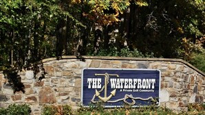A sign for "The Waterfront," a private golf community, mounted on a stone wall with a nautical anchor design. - Something Special - Firepit / Game/Movie Room / Dock (Moneta)