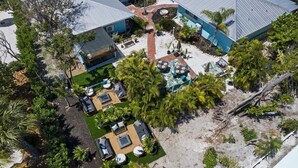 Un resort con varias edificaciones, zonas de estar al aire libre y palmeras.