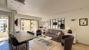 A modern living room with a sofa, a coffee table, and a TV. - 2 Room modern, terrace and Parking (Cannes)