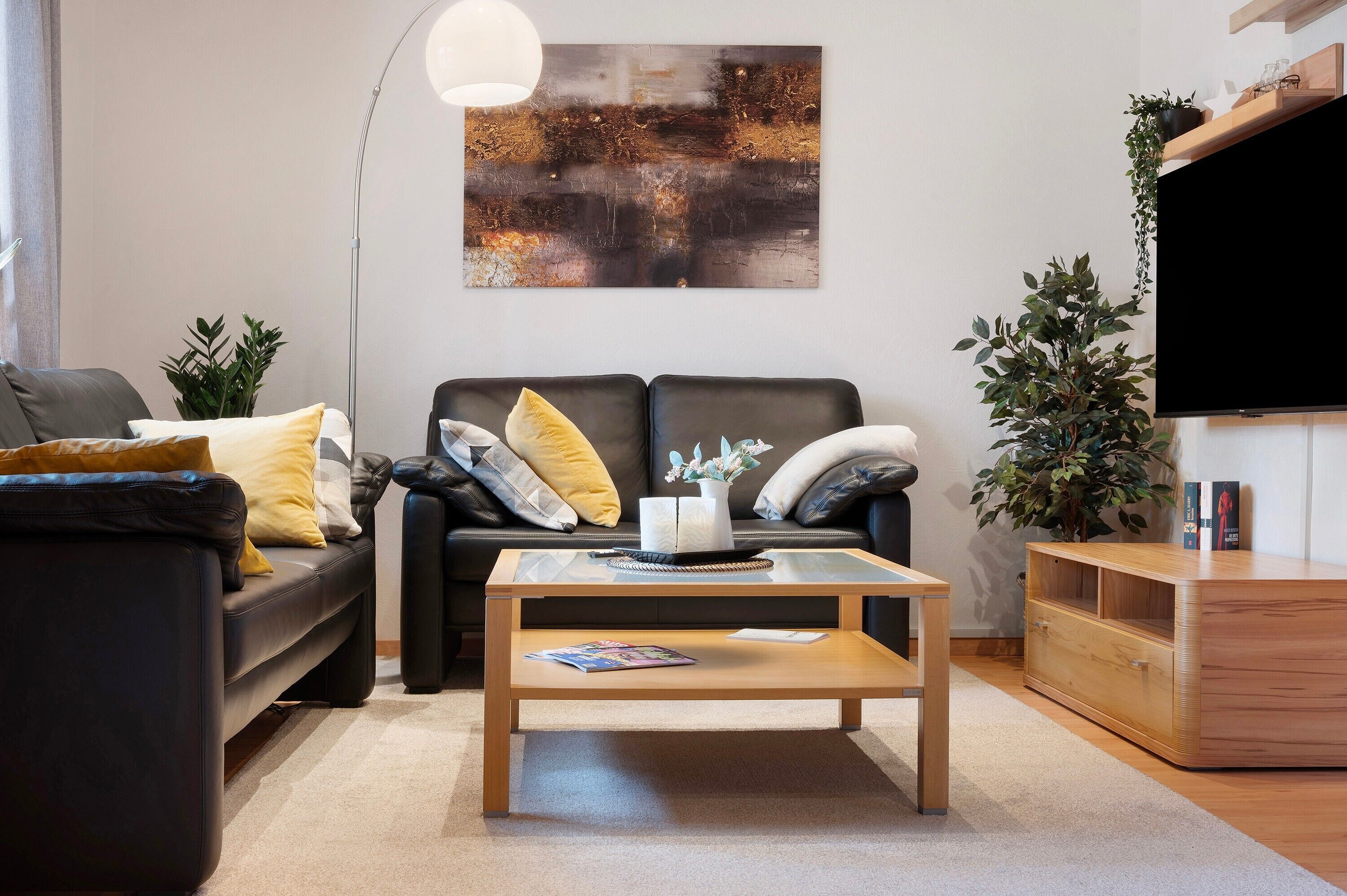 A modern living room with a sofa, coffee table, and a flat-screen TV.