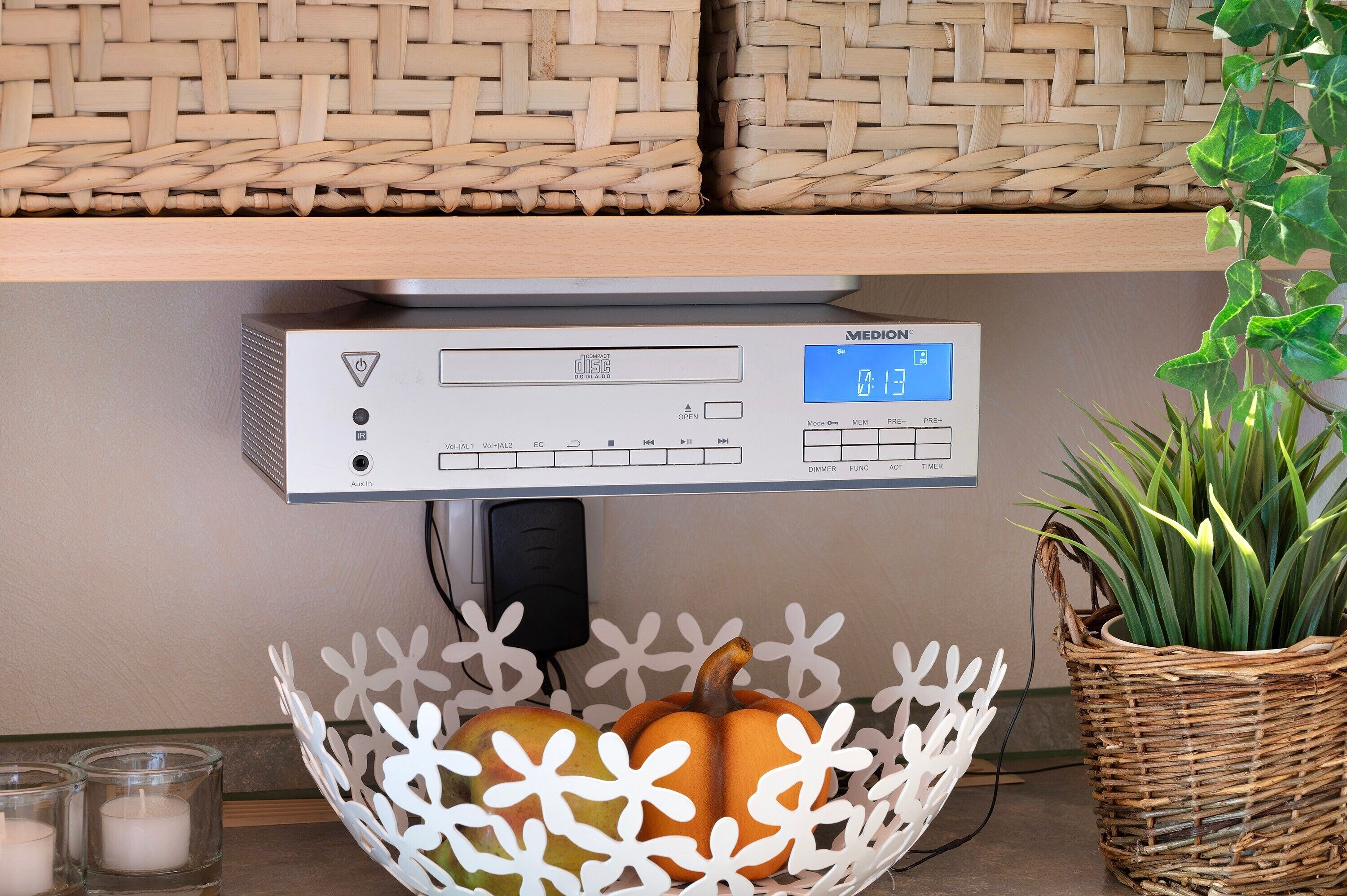 Un panel de control con pantalla digital, una cesta con adornos y una planta en maceta.