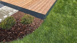 Un edificio in legno con un patio e un tavolo con sedie.