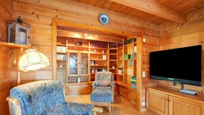 A wooden interior with a television, armchairs, a bookshelf, and a lamp. - Holiday Home 'Ferienhaus Sankt Peter' with Mountain View, Private Terrace and Wi-Fi (Dachsberg)