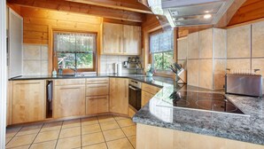 A kitchen with wooden cabinets, a glass backsplash, and a stainless steel range hood. - Holiday Home 'Ferienhaus Sankt Peter' with Mountain View, Private Terrace and Wi-Fi (Dachsberg)