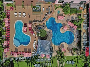 An aerial view of a resort with two large swimming pools, sun loungers, and umbrellas. - Spacious Ocean View Condo in Beachfront Hotel Resort Amenities 1608 (Miami Beach)