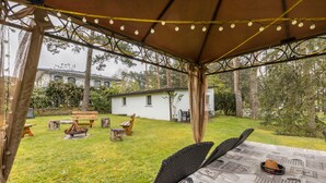 Eine Terrasse im Freien mit Tisch, Stühlen und einem Feuerkorb.
