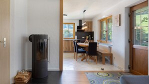 Una cocina moderna con armarios de madera, estufa integrada y un comedor con mesa y sillas.