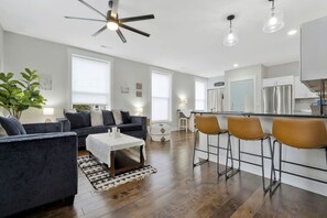 A modern kitchen with a central island, bar stools, and a ceiling fan. - *Sleeps 4* Downtown USA ~ Walkable Dickson Apt (Dickson)