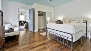 A bedroom with a metal bed frame, wooden flooring, a ceiling fan, and a view into another room. - *Sleeps 4* Downtown USA ~ Walkable Dickson Apt (Dickson)