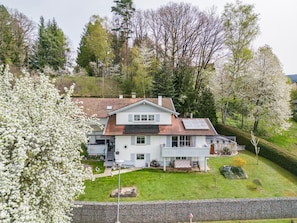 A two-story house with a sloped roof, a balcony, and a garden. - Apartment 'Ferienwohnung Plötz' with Shared Garden, Balcony and Wi-Fi (Bad Kötzting)