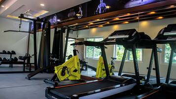 Ett gym med löpband, styrketräningsmaskiner och hantlar.