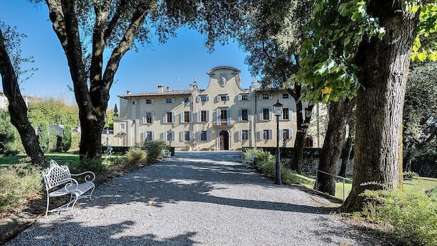 A building with a symmetrical facade, a central entrance, and a gravel path leading to it.