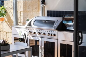 A stainless steel outdoor grill with four burners, a built-in thermometer, and a digital display. - Piccolo Waters -  Two story coastal home , Located on the scenic Mandurah canals (Halls Head)
