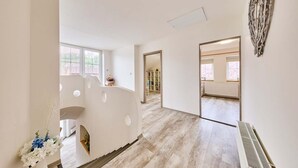 A spacious hotel corridor with wooden flooring, a radiator, and a decorative wall piece. - Chalupa Gita in Svoboda nad pou (Svoboda nad Upou)