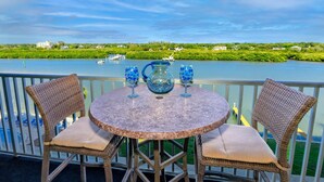 A round table with wicker chairs on a balcony overlooking a river. - Waterfront! Tennis/Pickleball, Pool, Grill Area, GOLF, BEACH,FUN FREE TICKETS Incl 509 Bayshores (Indian Shores)