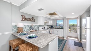 A kitchen with a marble countertop, white cabinets, and a view to the outside. - Waterfront! Tennis/Pickleball, Pool, Grill Area, GOLF, BEACH,FUN FREE TICKETS Incl 509 Bayshores (Indian Shores)