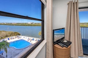 Ein Zimmer mit Blick auf einen Swimmingpool und ein Gewässer.